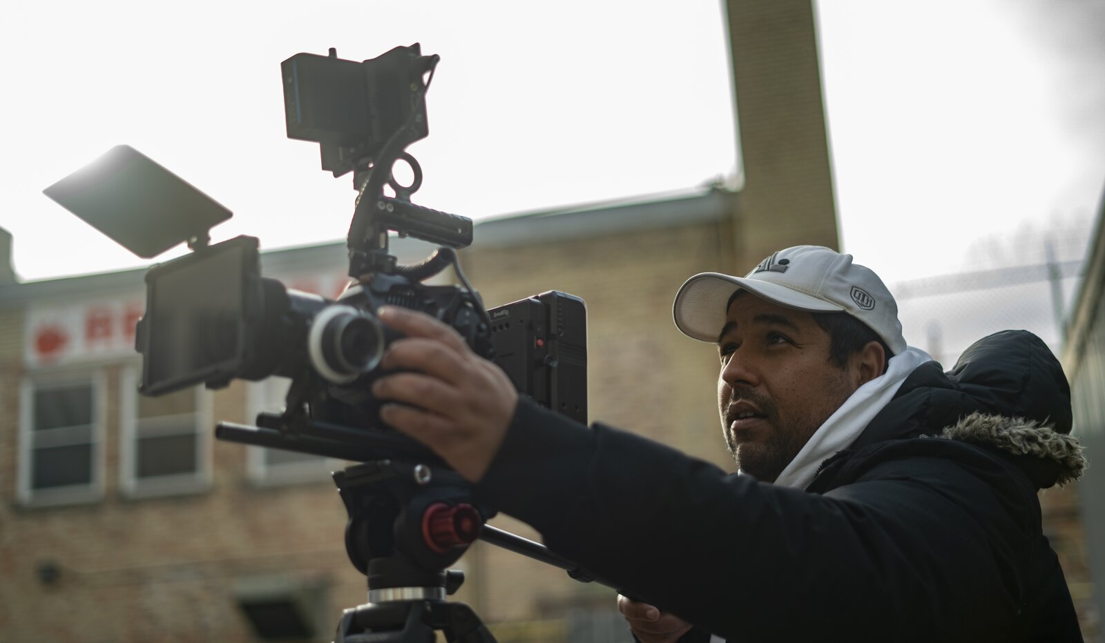 Wahbi Zarry behind the camera on a documentary shoot, wearing a white cap.